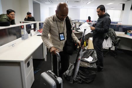 Employees of Utusan Malaysia pack before leaving their office during the last day of operation at company's headquarters in Kuala Lumpur