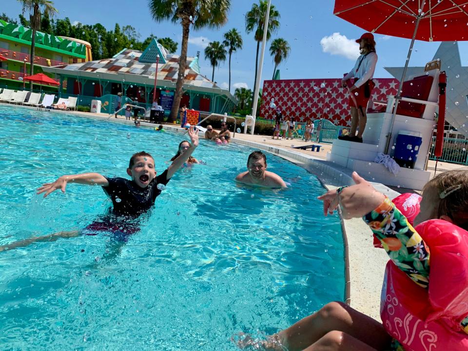 Kids playing in pool at Disney All-Star Music resort with lifeguard on the side