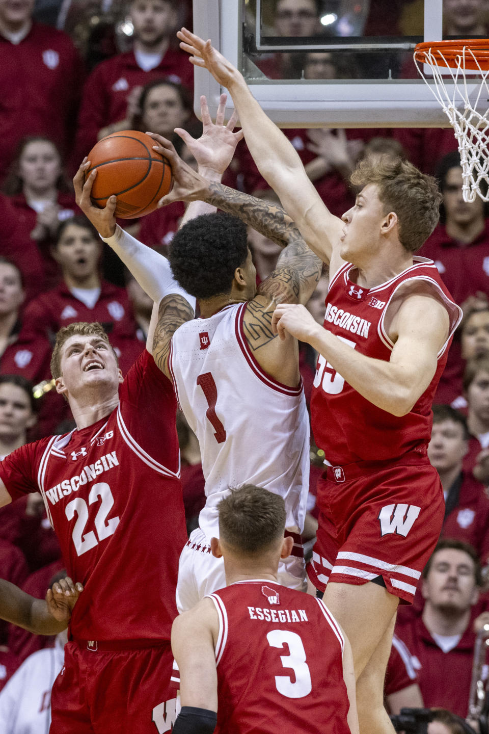 Wisconsin forward Steven Crowl (22) and Wisconsin forward Markus Ilver, right, defend a shot attempt by Indiana center Kel'el Ware (1) during the first half of an NCAA college basketball game, Tuesday, Feb. 27, 2024, in Bloomington, Ind. (AP Photo/Doug McSchooler)