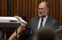 Forensic expert, Roger Dixon, holds up a court exhibit, a prosthesis belonging to Oscar Pistorius, as he answers questions put to him by chief state prosecutor Gerrie Nel , during the murder trial of Pistorius, in Pretoria, South Africa, Thursday, April 17, 2014. Pistorius is charged with the murder of his girlfriend, Reeva Steenkamp, on Valentines Day in 2013. (AP Photo/Themba Hadebe, Pool)