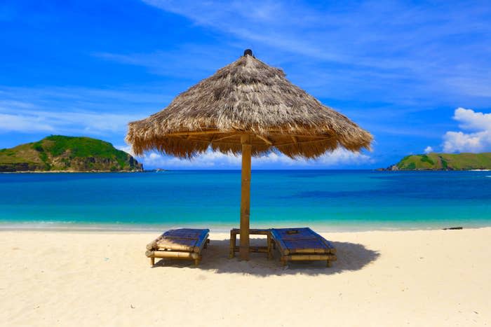 Cabana with two chairs in front of ocean on beach