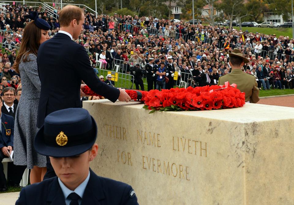 Britains Prince William (C) and his wife Catherine, Duchess of Cambridge, lay a wreath at the cenotaph during the ANZAC Day march at the Australian War Memorial in Canberra on April 25, 2014. Britain's Prince William, his wife Kate and their son Prince George were on a three-week tour of New Zealand and Australia. AFP PHOTO / Saeed KHAN        (Photo credit should read SAEED KHAN/AFP via Getty Images)