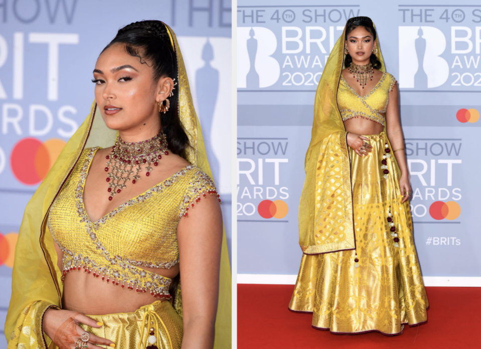 Celebrity posing in a traditional yellow embellished outfit with jewelry at BRIT Awards