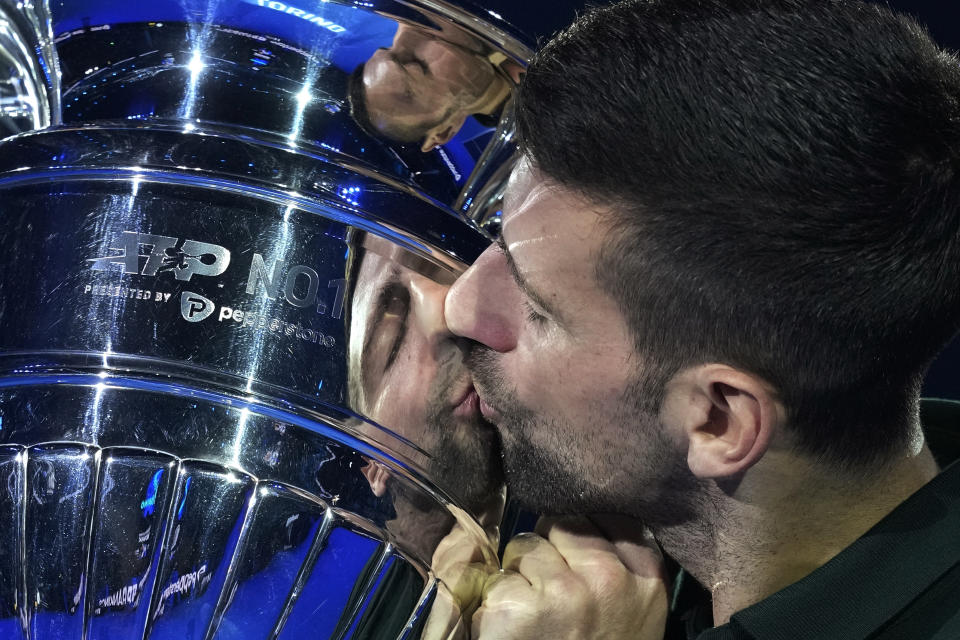 Serbia's Novak Djokovic kisses the trophy as ATP world best player at the ATP World Tour Finals, at the Pala Alpitour, in Turin, Italy, Monday, Nov. 13, 2023. Djokovic was presented with the trophy for finishing the year ranked No. 1. (AP Photo/Antonio Calanni)