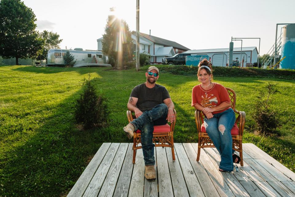 Sasha and Craig Poole look out over their property after giving a tour of their current business endeavor, a 1973 Airstream Land Yacht trailer being renovated to soon become Sunshine Gypsy Boutique, in Warren Township. The family also owns livestock and crops.