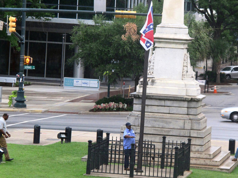 Workers raise the flag at a Confederate monument in front of the Statehouse in Columbia, S.C. Saturday, June, 27, 2015. 