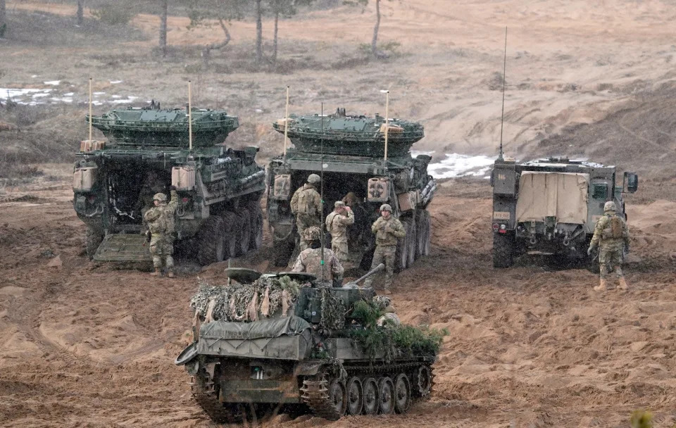 NATO troops in armoured vehicles on muddy ground