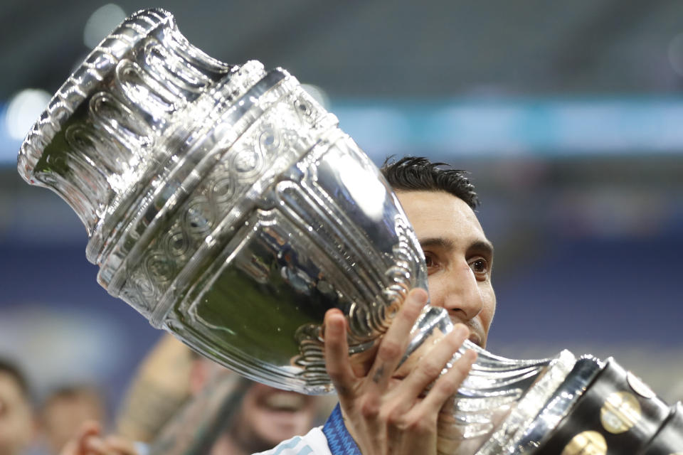 Argentina's Angel Di Maria holds the trophy as he celebrates with teammates after beating 1-0 Brazil in the Copa America final soccer match at the Maracana stadium in Rio de Janeiro, Brazil, Saturday, July 10, 2021. (AP Photo/Andre Penner)