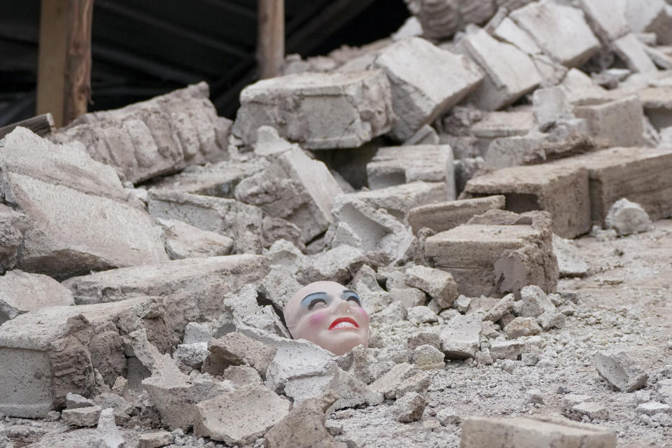 A mask lays on the rubble of a building destroyed after a deadly landslide in Alausi, Ecuador, Monday, March 27, 2023. (AP Photo/Dolores Ochoa)