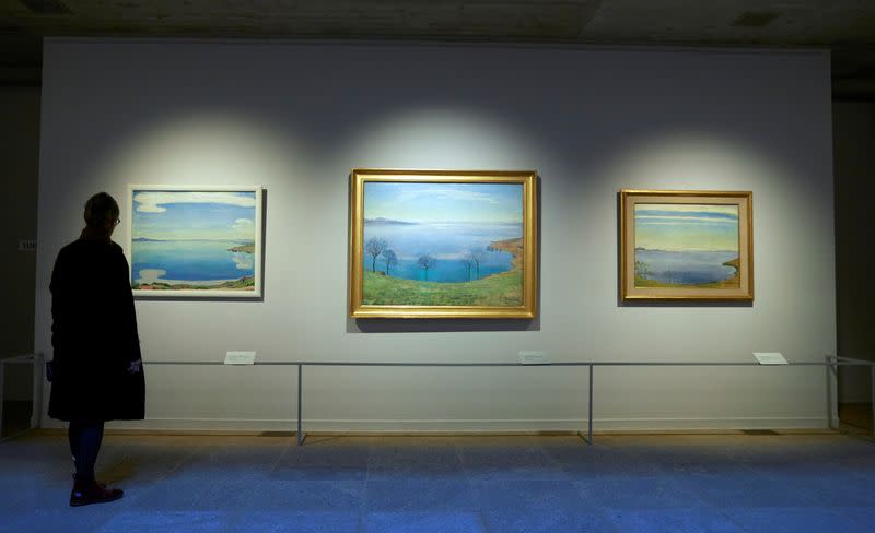 A visitor looks at paintings by Holder at the Fondation Gianadda in Martigny