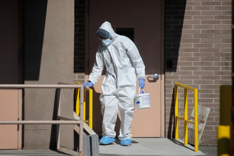 Worker disinfects handrails outside Wyckoff Heights Medical Center during outbreak of coronavirus disease (COVID-19) in New York