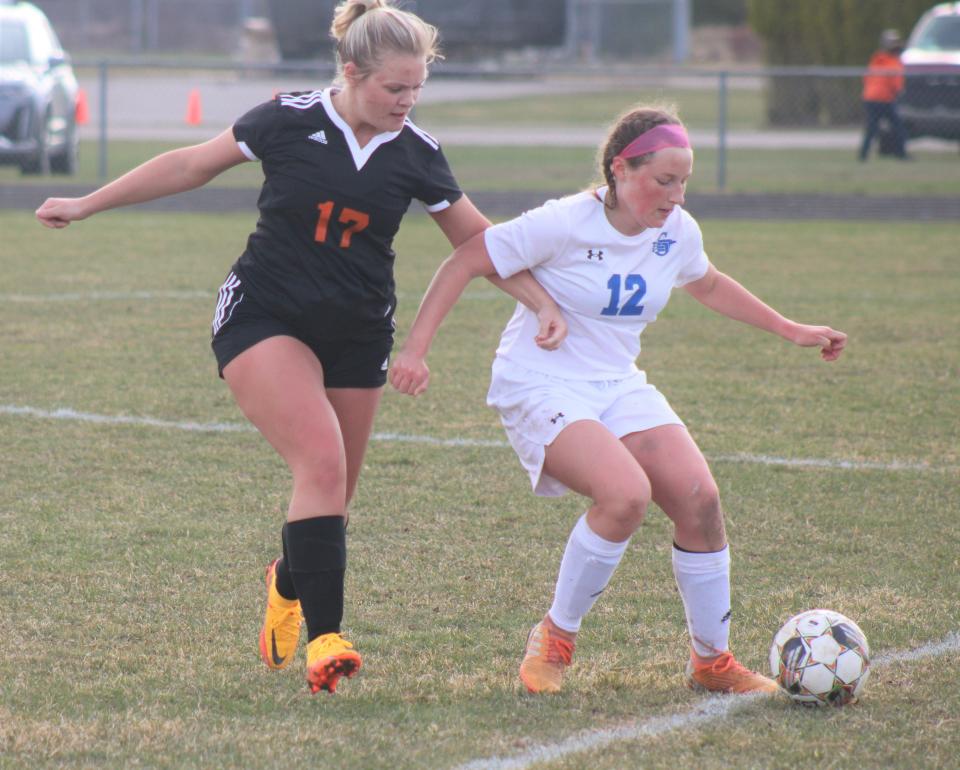 Cheboygan junior Katie Seebeck (12) looks to keep the ball away from Cheboygan senior Anna Hudson (17) during the second half on Friday.