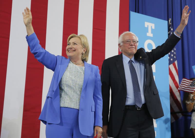 Democratic U.S. presidential candidates Clinton and Sanders stand together during campaign rally in Portsmouth, New Hampshire