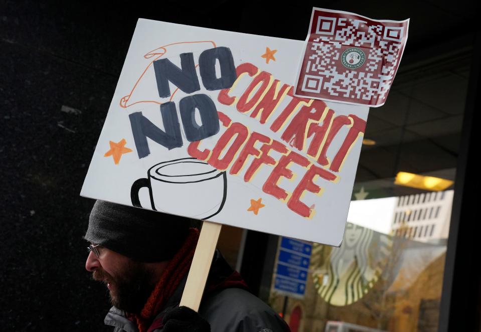 Nov. 17, 2022; Columbus, Ohio, USA; Barista Ben Baldwin holds a sign and passes out information as he and others joined national Starbucks workers on strike Thursday at the corner of Broad and Third Streets in downtown. The walkouts at more than 100 U.S. stores coincide with Starbucks' annual Red Cup Day, when the company gives free reusable cups to customers who order a holiday drink--often one of the busiest days of the year. Mandatory Credit: Barbara J. Perenic/Columbus Dispatch