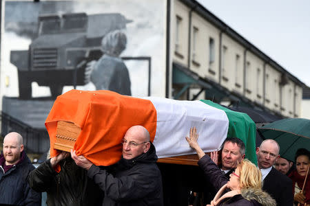 A woman touches the coffin of Martin McGuinness as it is carried through the streets of Londonderry, Northern Ireland, March 21, 2017. REUTERS/Clodagh Kilcoyne