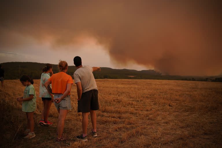 Vecinos mirando a un incendio forestal cerca de Tarragona, en la región nororiental de Cataluña, España