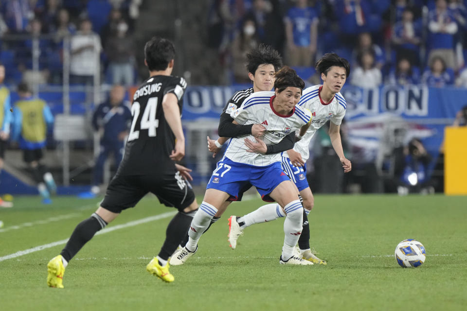 Yokohama F. Marinos' Ken Matsubara, center, is blocked by Ulsan Hyundai's Lee Dong-gyeong during the first leg of the AFC Champions League semifinal soccer match at the Ulsan Munsu Football Stadium in Ulsan, South Korea, Wednesday, April 17, 2024. (AP Photo/Ahn Young-joon)