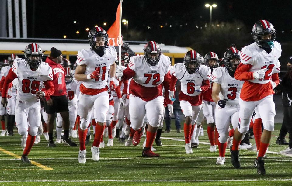 Aliquippa players run onto the field prior to the game Bishop McDevitt in the PIAA Class 4A championship football game, Dec. 9, 2021, at HersheyPark Stadium in Hershey. The Quips defeated the Crusaders 34-27. 