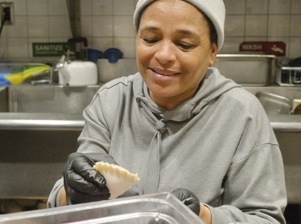 Marilin Jimenez, 50, prepares empanadas at Dina's Authentic Dominican Kitchen inside the Flagship City Food Hall. She is the mother of Dina Csir, who owns the restaurant with her husband John Csir.