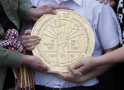 Pro-democracy student leaders hold a plaque declaring "This country belongs to the people" at the Sanam Luang field during a protest in Bangkok, Thailand, Sunday, Sept. 20, 2020. Thousands of demonstrators turned out Saturday for a rally to support the student-led protest movement's demands for new elections and reform of the monarchy. (AP Photo/Sakchai Lalit)