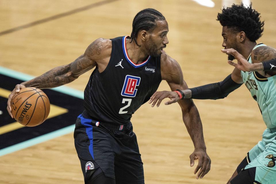 Los Angeles Clippers forward Kawhi Leonard (2) brings the ball up court while guarded by Charlotte Hornets forward Jalen McDaniels during the first half of an NBA basketball game in Charlotte, N.C., Thursday, May 13, 2021. (AP Photo/Jacob Kupferman)