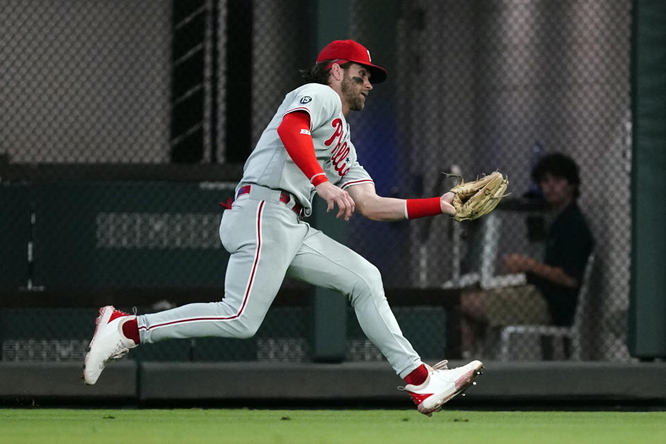 Philadelphia Phillies right fielder Bryce Harper (3) makes a running catch to retire Atlanta Braves' Travis d'Arnaud in the second inning of a baseball game Wednesday, Sept. 29, 2021, in Atlanta. (AP Photo/John Bazemore)