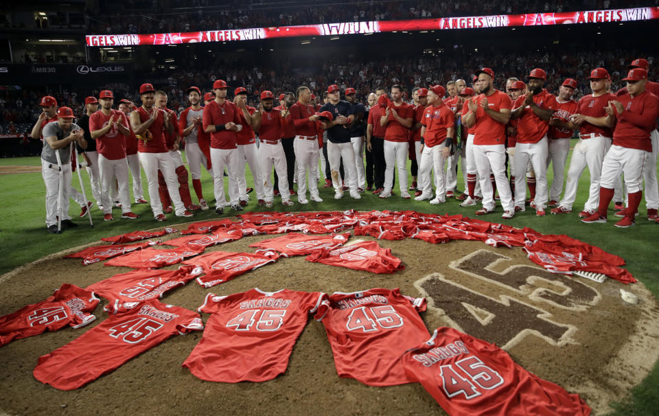 Members of the Los Angeles Angels place their jerseys with No. 45 in honor of pitcher Tyler Skaggs on the mound after a combined no-hitter against the Seattle Mariners during a baseball game Friday, July 12, 2019, in Anaheim, Calif. The Angels won 13-0. (AP Photo/Marcio Jose Sanchez)