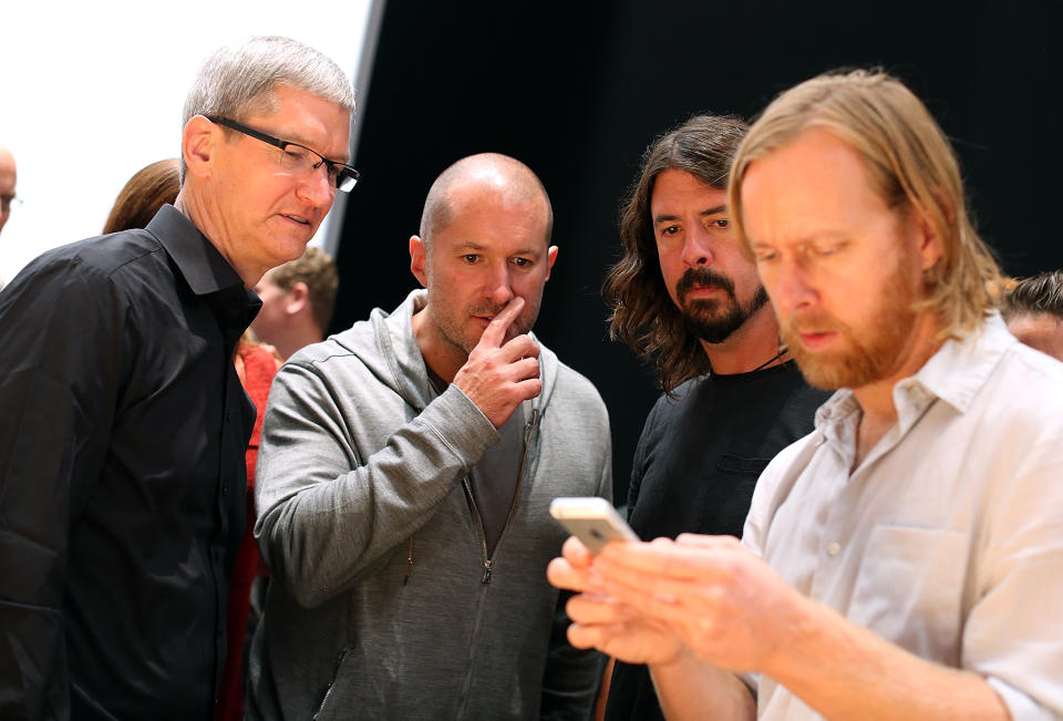 SAN FRANCISCO, CA - SEPTEMBER 12: (L-R) Apple CEO Tim Cook, Apple senior vice president of Industrial Design Jonathan Ive and Dave Grohl of the Foo Fighters look on as an attendee looks at the new iPhone 5 during an Apple special event at the Yerba Buena Center for the Arts on September 12, 2012 in San Francisco, California. Apple announced the iPhone 5, the latest version of the popular smart phone. (Photo by Justin Sullivan/Getty Images)