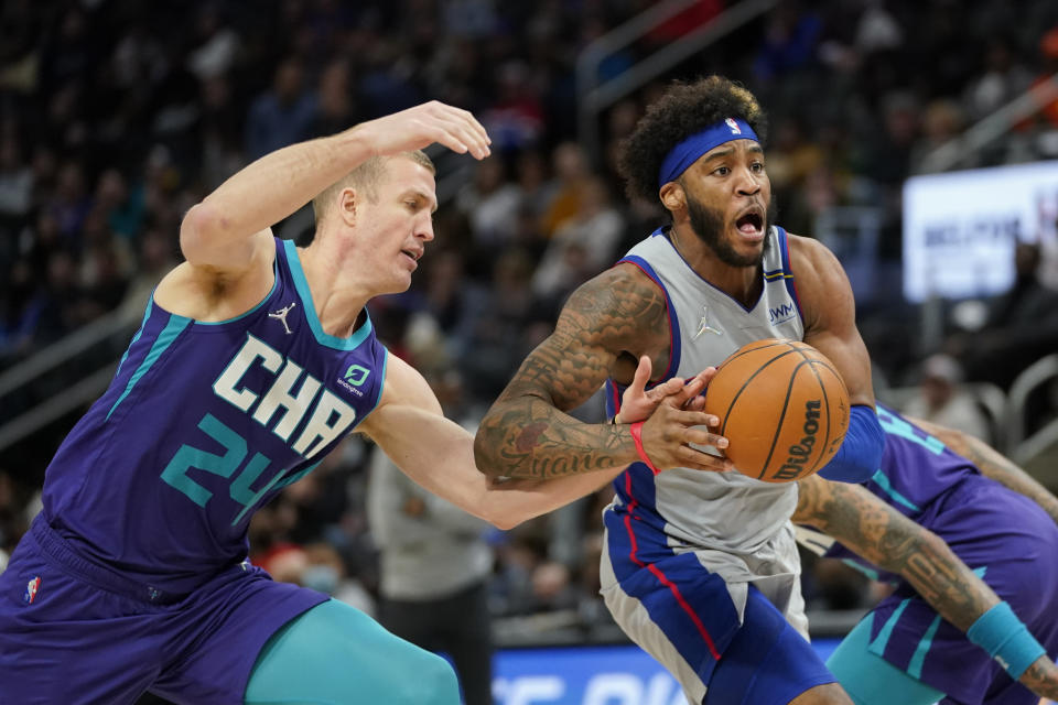 Detroit Pistons forward Saddiq Bey (41) drives on Charlotte Hornets center Mason Plumlee (24) in the second half of an NBA basketball game in Detroit, Friday, Feb. 11, 2022. (AP Photo/Paul Sancya)