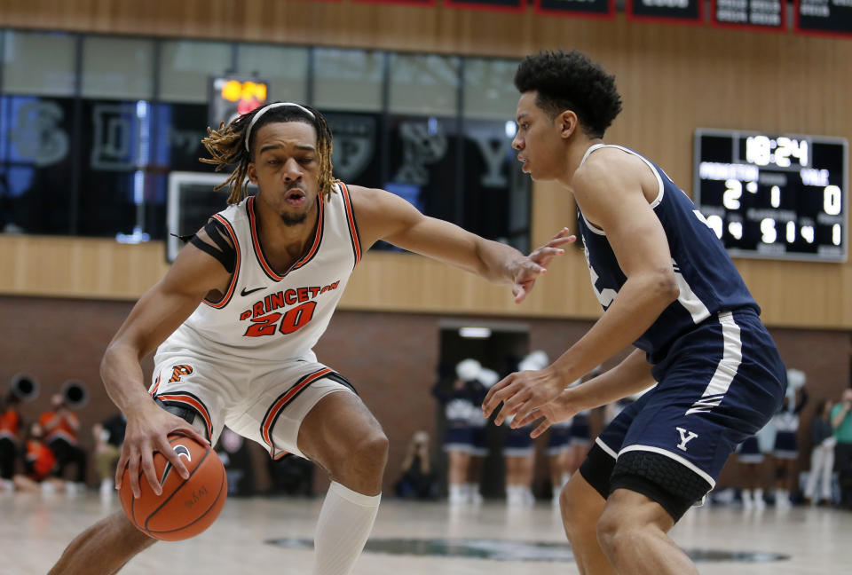 FILE - Princeton forward Tosan Evbuomwan (20) drives against Yale forward Isaiah Kelly during the first half of an NCAA Ivy League men's college basketball championship game on March 13, 2022, in Cambridge, Mass. Although he’s a 6-foot-8 forward, Evbuomwan led the Ivy League in assists last season with 5.1 per game. He was named the Ivy player of the year. (AP Photo/Mary Schwalm, File)