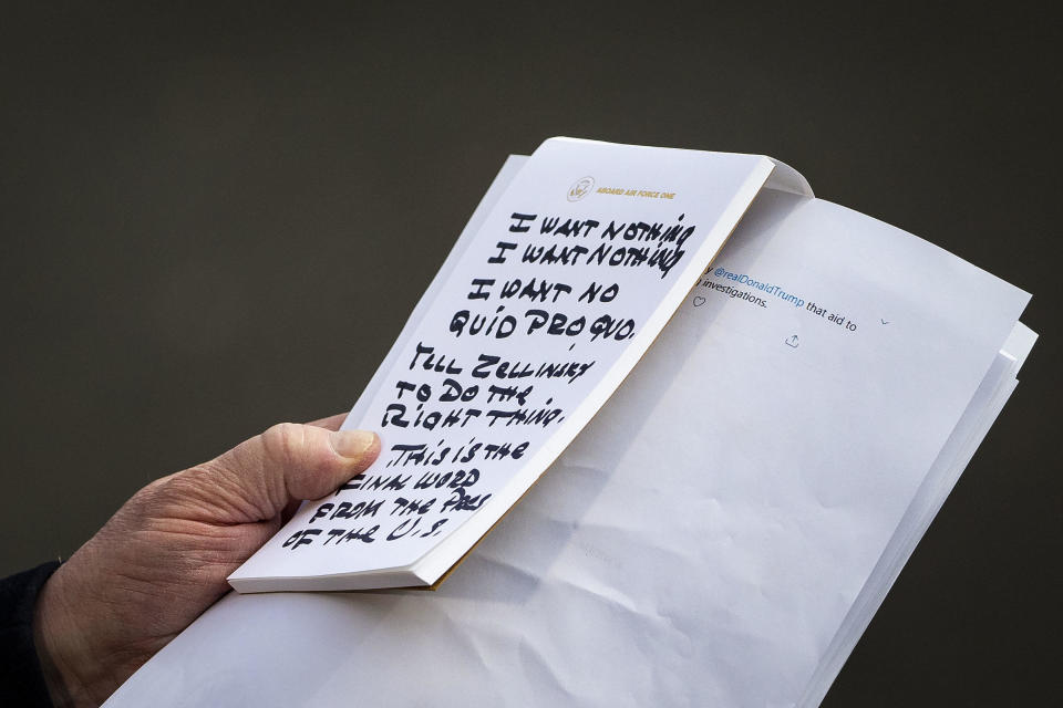 President Donald Trump reads from a handwritten note while speaking to members of the media before boarding Marine One on the South Lawn of the White House on Wednesday, November 20, 2019. / Credit: Al Drago/Bloomberg via Getty Images