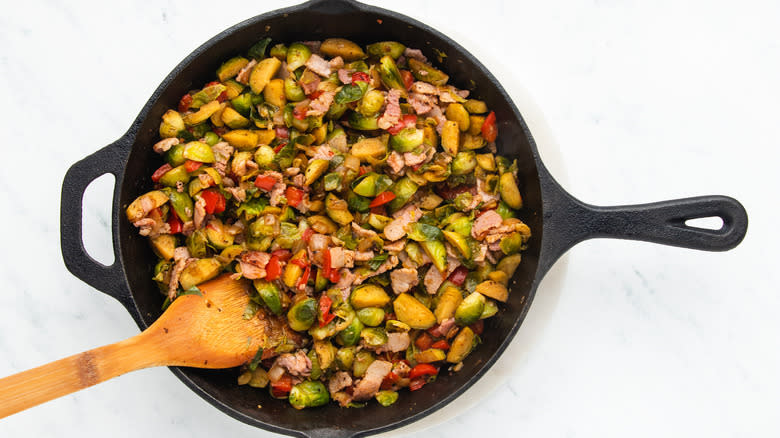 Brussels sprouts hash in skillet with wooden spatula
