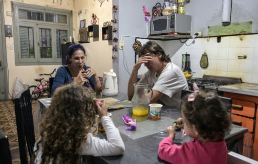 Between the two of them, Argentine couple carpenter Ariel Fernandez (2nd R) and his wife, teacher Natalia Morales (L), earn the equivalent of around $1,200 a month as more and more people in the country fall below the poverty line