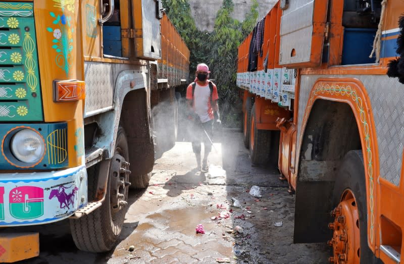 A municipal works as he disinfects parked supply truck at a yard during a 21-day nationwide lockdown to limit the spreading of coronavirus disease (COVID-19), on the outskirts of Kolkata