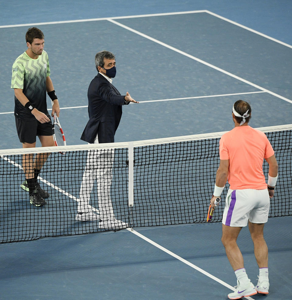 Spain's Rafael Nadal, right, and Britain's Cameron Norrie, left, meet at the net for the coin toss before their third round match a the Australian Open tennis championships in Melbourne, Australia, Saturday, Feb. 13, 2021. (AP Photo/Andy Brownbill)
