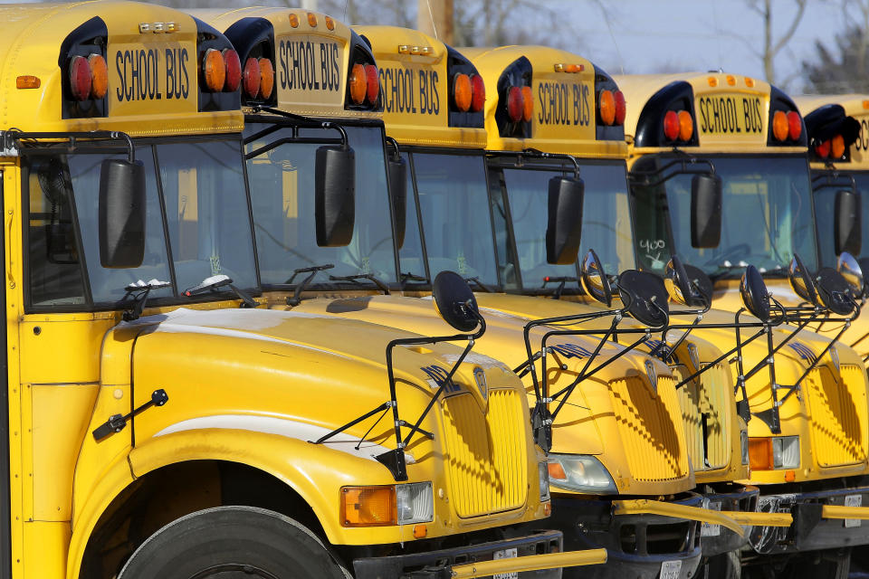 FILE - In this Jan. 7, 2015 file photo, public school buses are parked in Springfield, Ill. It might seem like you’ve been saving for back to school since you packed your children’s backpacks last fall. But after replacing worn-out erasers, outgrown clothes and an outdated laptop, you may still feel the financial pinch. (AP Photo/Seth Perlman, File)