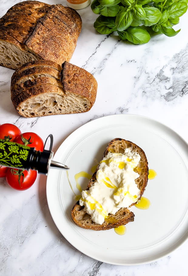 Drizzling olive oil on burrata toast <p>Courtesy of Jessica Wrubel</p>