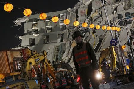 Soldiers stand guard in front of 17-storey apartment building collapsed after an earthquake, on the first day of the Chinese Lunar New Year at Tainan, southern Taiwan February 8, 2016. REUTERS/Tyrone Siu