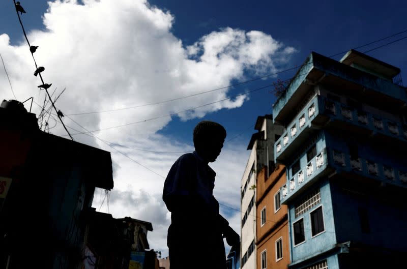 FILE PHOTO: A worker stands in front of a closed essential food store during a nationwide strike in Colombo, Sri Lanka