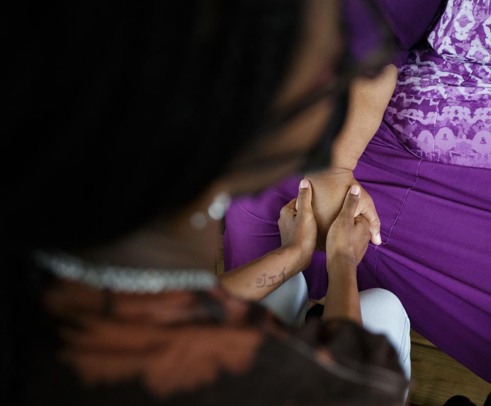 Imani Alexander, 15, holds her grandmother Lisa Herring's hand as Herring speaks about her daughter Shannon Robinson, who died from COVID-19 in January, Tuesday, Oct. 5, 2021.