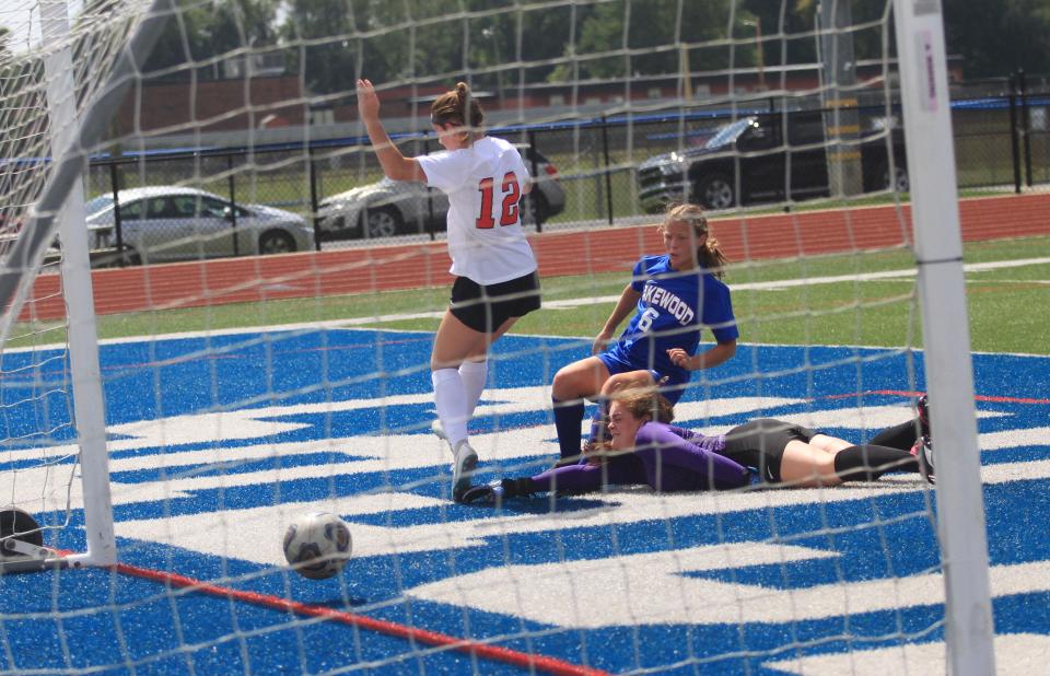 Lakewood's Ellie Conaway shoots a rebound past Alexander's Morgan Mitchell and goalkeeper Monica Thompson on Saturday.