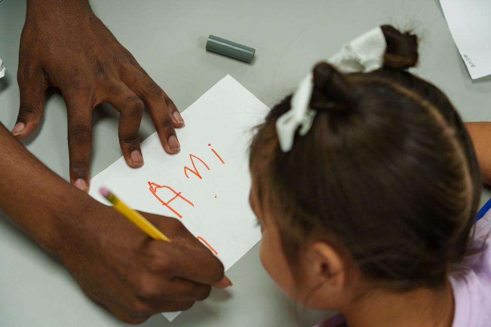 Mia Ochoa Quintana, 4, watches as Taigee Dillard demonstrates how to write Mia's name at Desert Garden Preschool in Glendale on Sept. 21, 2023.
