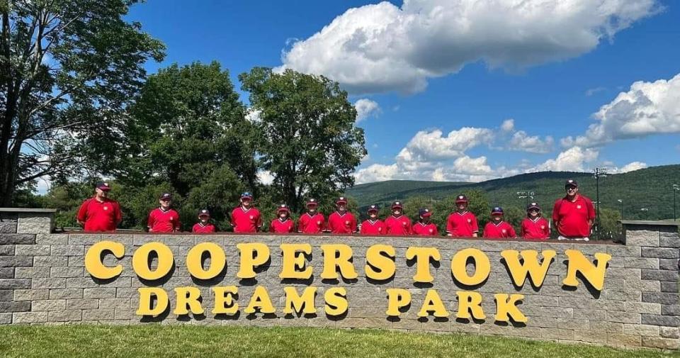 The Dover Dirt Dawgs pose at the entrance of Dreams Park in Cooperstown, New York.