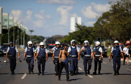 Riot-police are seen in line behind an university student during a protest against cuts to federal spending on higher education planned by Brazil's President Jair Bolsonaro's right-wing government in Brasilia, Brazil May 15, 2019. REUTERS/Adriano Machado