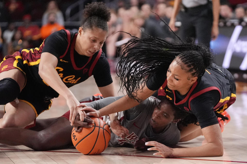 Washington State center Bella Murekatete, center, struggles for a loose ball with Southern California forward Kaitlyn Davis, left, and guard Taylor Bigby during the first half of an NCAA college basketball game Friday, Jan. 26, 2024, in Los Angeles. (AP Photo/Mark J. Terrill)