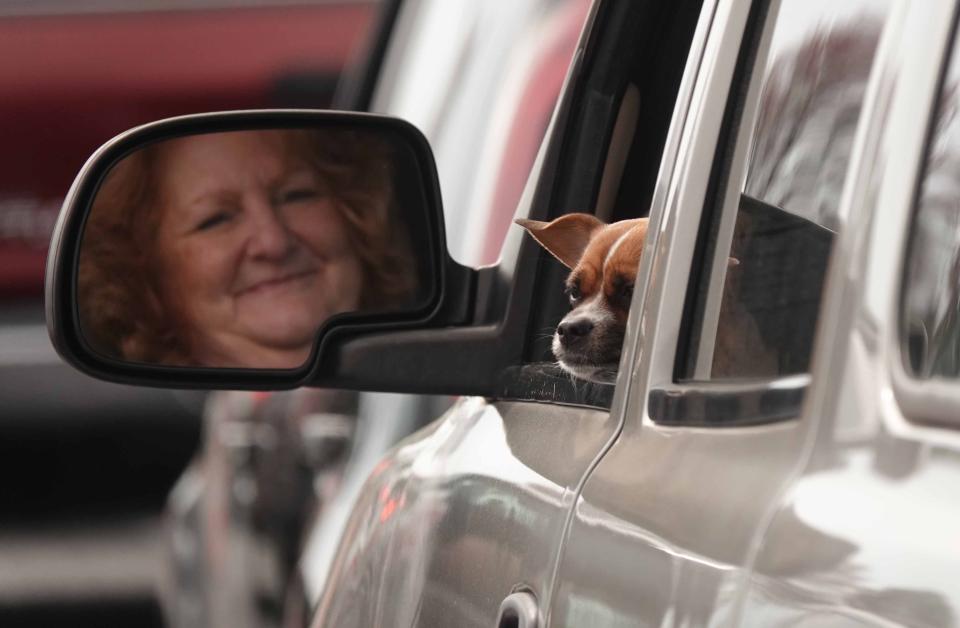 Shirley Pierce, of Smyrna, Delaware, and her dog Daisey Mae, wait in line with more than a thousand other vehicles at Dover International Speedway's parking lot to receive food from the Food Bank of Delaware on its third emergency mobile drive-thru pantry on March 20.