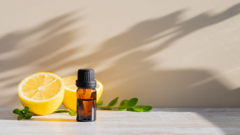 A halved lemon and essential oil