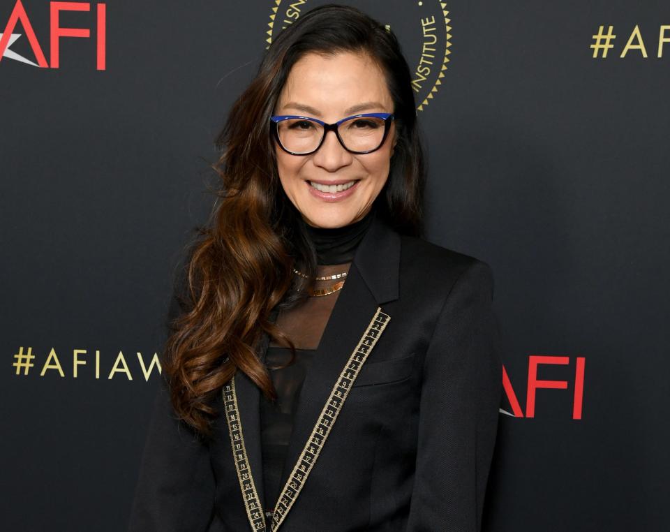 A close-up of Michelle smiling and wearing glasses