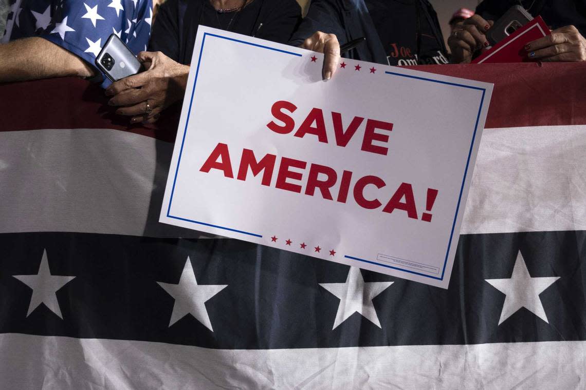 Republican supporter holds a Save America sign at a rally Saturday for former President Donald Trump at the Minden Tahoe Airport in Minden, Nev.