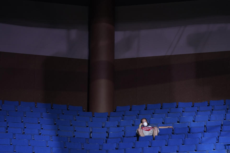 FILE - In this June 20, 2020, file photo, a supporter of President Donald Trump sits in the stands wearing a face mask during a campaign rally at the BOK Center in Tulsa, Okla. (AP Photo/Evan Vucci, File)